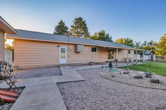 back of house with a patio and a lawn