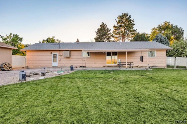 rear view of property featuring a patio and a yard