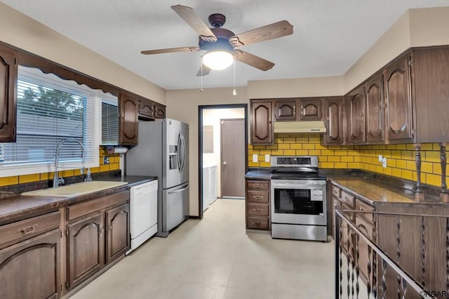 kitchen with sink, ceiling fan, appliances with stainless steel finishes, backsplash, and dark brown cabinets