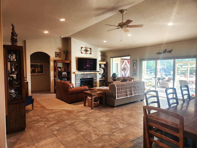 1381 3rd St, Penrose, CO 81240 - tiled living room featuring a fireplace, vaulted ceiling, a textured ceiling, and ceiling fan