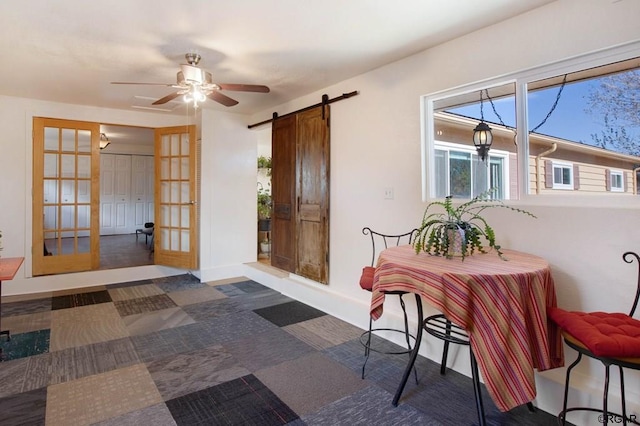 interior space featuring a barn door and ceiling fan