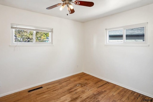 empty room with hardwood / wood-style floors and ceiling fan