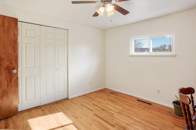 unfurnished bedroom featuring light wood-type flooring, ceiling fan, and a closet