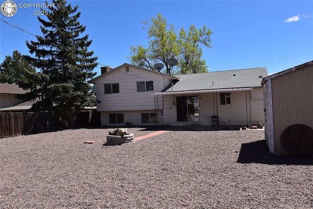 back of house featuring fence, a patio, and a fire pit