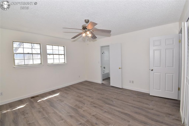 unfurnished bedroom with baseboards, a textured ceiling, and wood finished floors