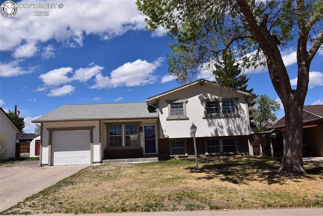 tri-level home featuring an attached garage, stucco siding, driveway, and a front lawn