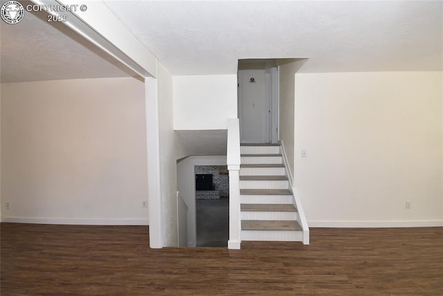 staircase featuring baseboards and wood finished floors