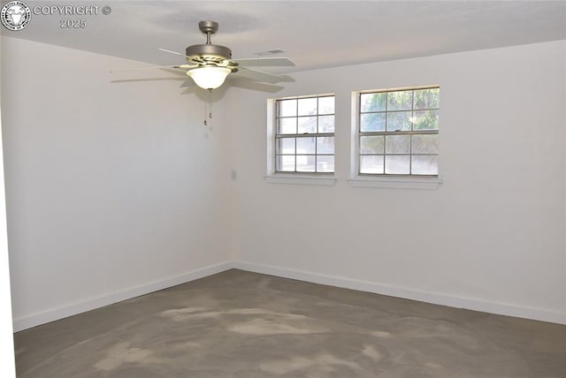 empty room featuring a ceiling fan, baseboards, and concrete flooring