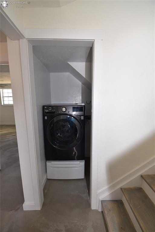 laundry room featuring baseboards and washer / clothes dryer