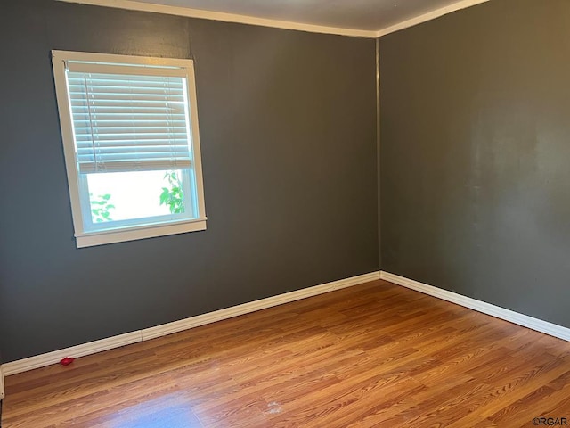 empty room featuring ornamental molding and hardwood / wood-style floors