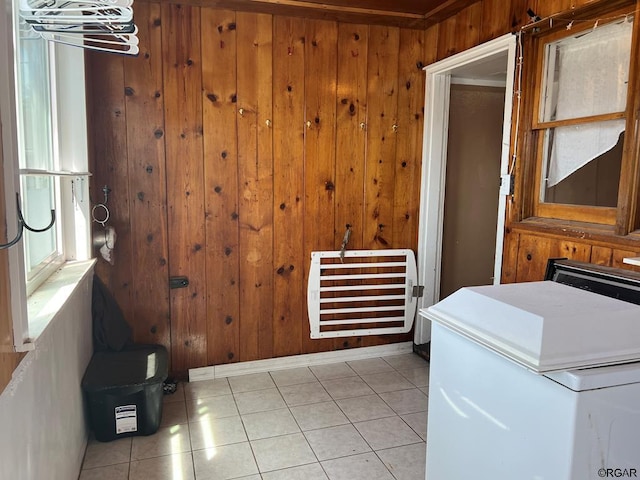 laundry room featuring light tile patterned flooring and wood walls