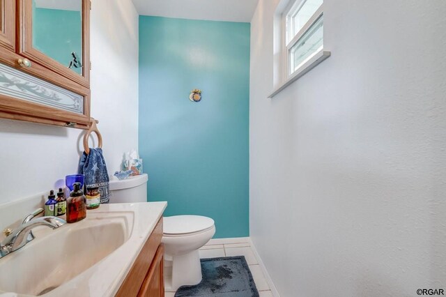 bathroom featuring vanity, tile patterned floors, and toilet