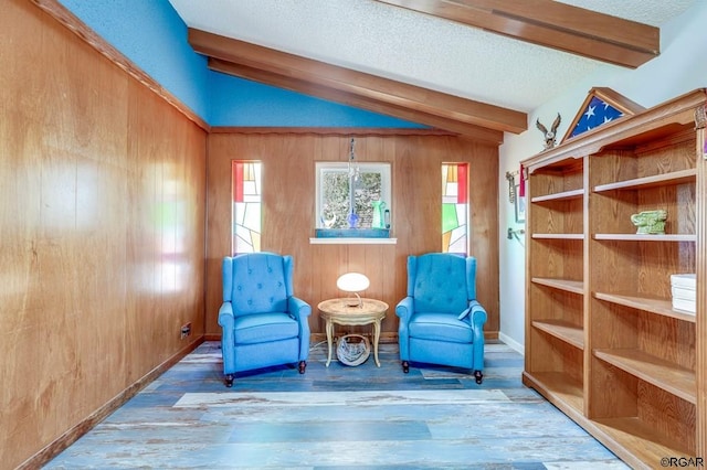 living area featuring vaulted ceiling with beams, hardwood / wood-style floors, a textured ceiling, and wood walls