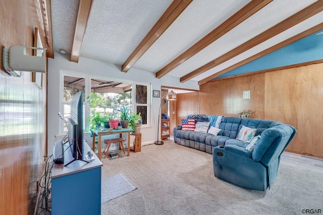 living room featuring wooden walls, lofted ceiling with beams, a textured ceiling, and carpet flooring