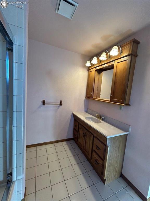 2324 W Willamette Ave, Colorado Springs, CO 80904 - full bath featuring a shower, vanity, baseboards, and tile patterned flooring
