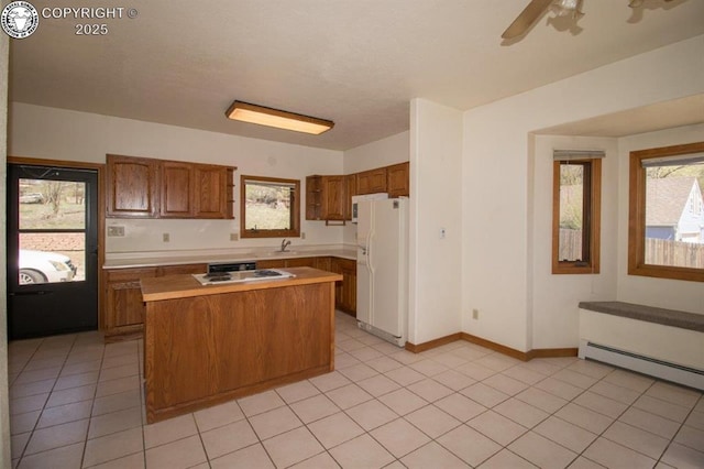 2324 W Willamette Ave, Colorado Springs, CO 80904 - kitchen featuring white appliances, light countertops, brown cabinetry, a wealth of natural light, and a baseboard heating unit
