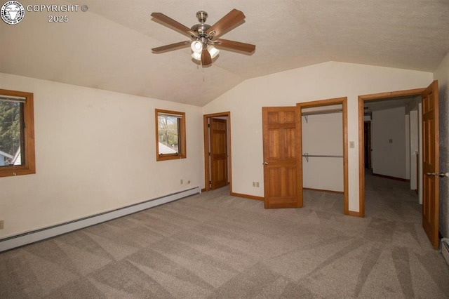 2324 W Willamette Ave, Colorado Springs, CO 80904 - unfurnished bedroom featuring a walk in closet, baseboard heating, baseboards, lofted ceiling, and carpet