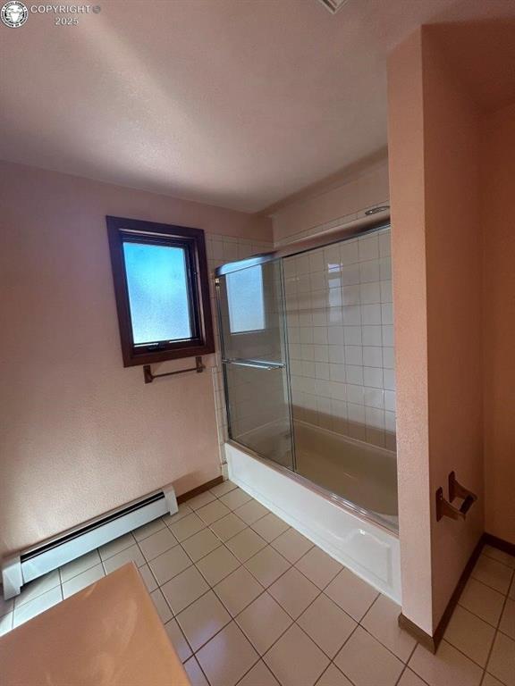 2324 W Willamette Ave, Colorado Springs, CO 80904 - full bathroom with tile patterned flooring, a baseboard radiator, baseboards, and shower / bath combination with glass door