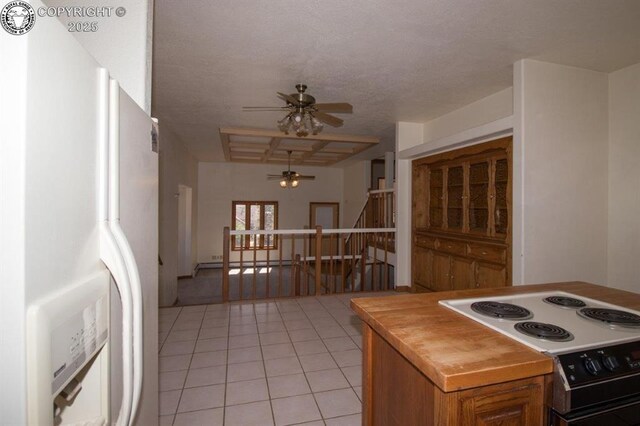 2324 W Willamette Ave, Colorado Springs, CO 80904 - kitchen with brown cabinetry, light tile patterned flooring, ceiling fan, white refrigerator with ice dispenser, and electric stove