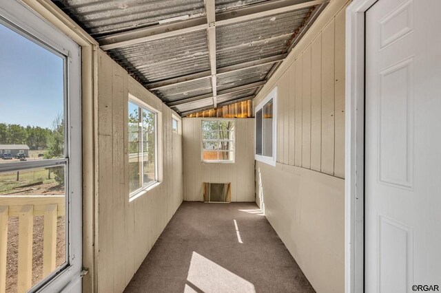 unfurnished sunroom featuring vaulted ceiling