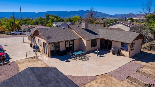 back of property featuring a mountain view, a patio area, and central air condition unit