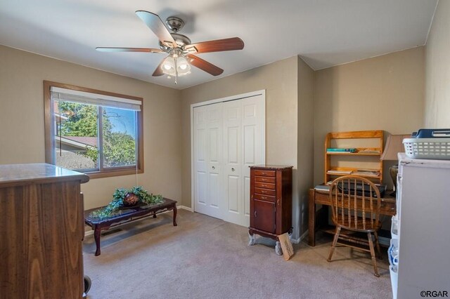 office space featuring light carpet and ceiling fan