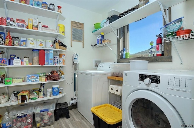 washroom with light hardwood / wood-style floors and washer and dryer