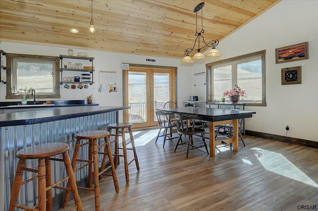 dining area with lofted ceiling, hardwood / wood-style floors, wood ceiling, and french doors