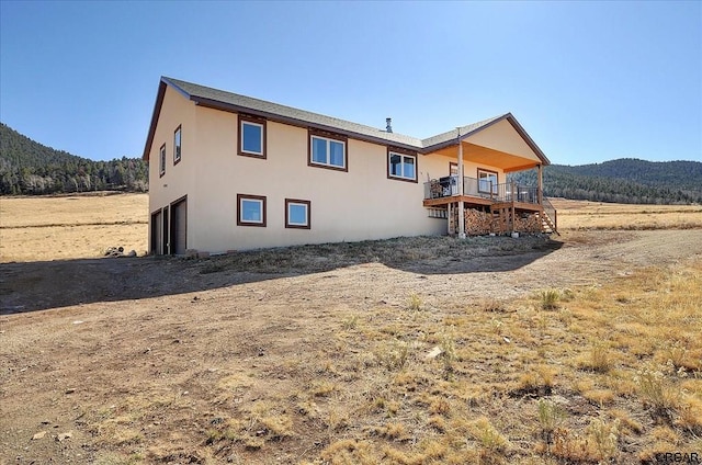 back of house featuring a mountain view and a garage