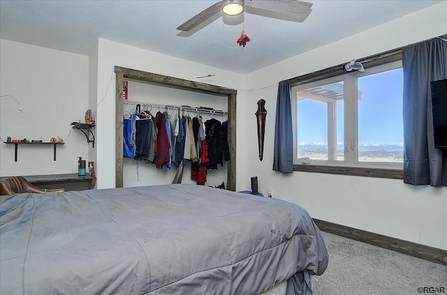 carpeted bedroom with ceiling fan and a closet