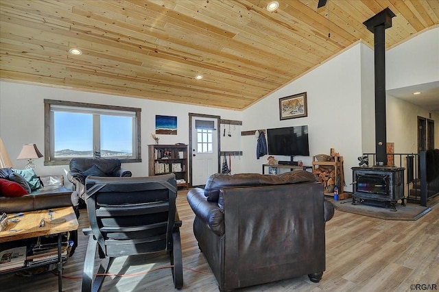 living room featuring wood ceiling, vaulted ceiling, hardwood / wood-style floors, and a wood stove