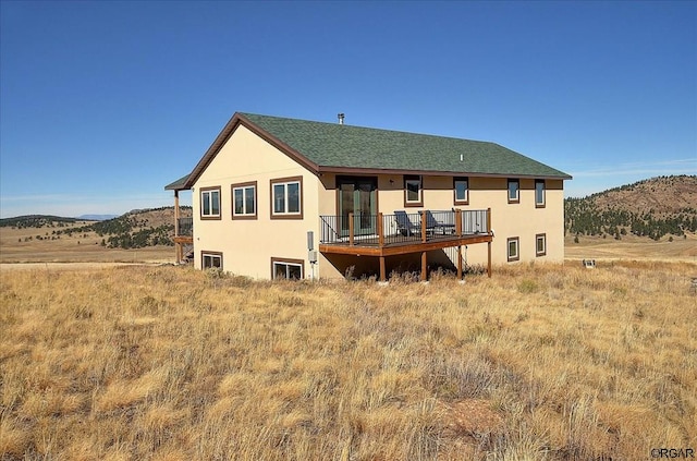 back of property featuring a deck with mountain view