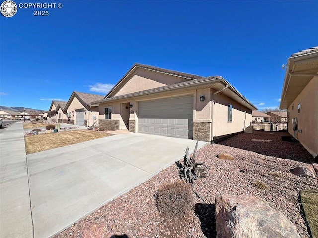 ranch-style home featuring a garage, concrete driveway, stone siding, a residential view, and stucco siding