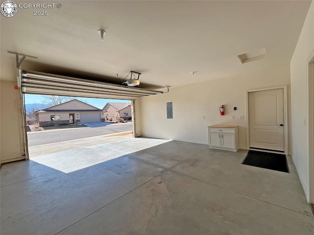 garage featuring electric panel and a garage door opener