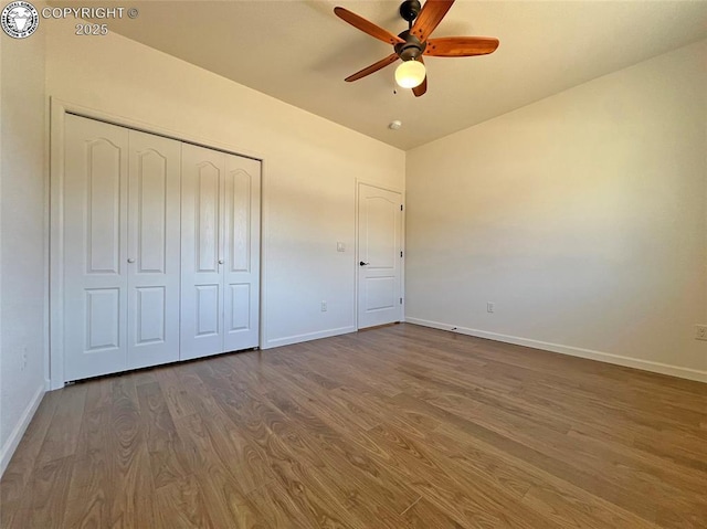 unfurnished bedroom with a closet, baseboards, and wood finished floors