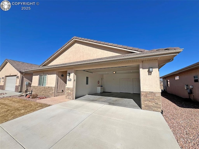 single story home with stone siding, driveway, an attached garage, and stucco siding