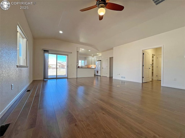 unfurnished living room featuring lofted ceiling, ceiling fan, dark wood finished floors, and visible vents