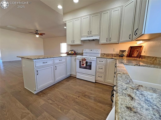 kitchen with a peninsula, under cabinet range hood, white cabinets, and white electric range