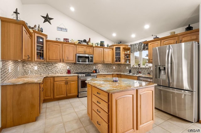 kitchen featuring vaulted ceiling, stainless steel appliances, a center island, and light tile patterned flooring