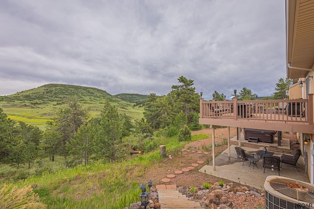 view of yard with a patio, central AC, and a deck with mountain view