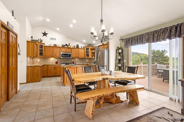 dining space with light tile patterned flooring, lofted ceiling, and a notable chandelier