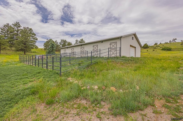 view of outdoor structure featuring a rural view and a garage