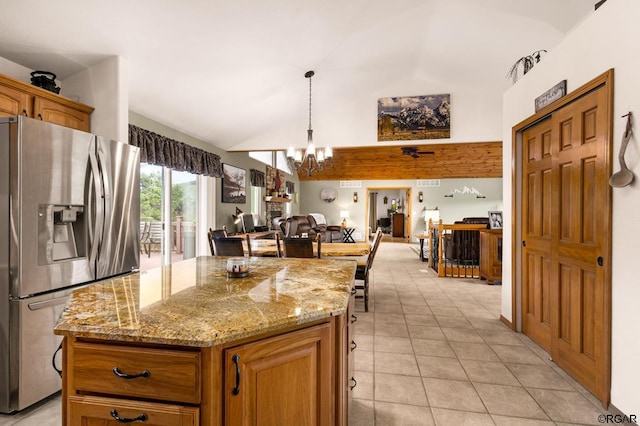 kitchen featuring an inviting chandelier, a center island, stainless steel fridge with ice dispenser, and light stone counters