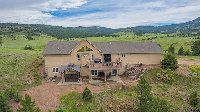 back of property featuring a gazebo, a deck with mountain view, and a patio area