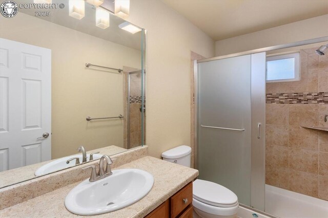 bathroom featuring vanity, an enclosed shower, and toilet