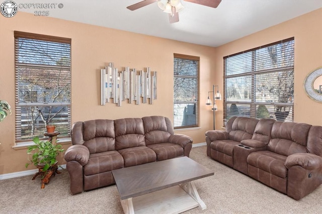 living room with a wealth of natural light, ceiling fan, and carpet