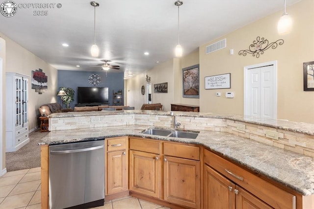 kitchen with dishwasher, sink, light tile patterned floors, and decorative light fixtures