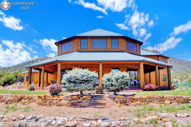 back of house with a mountain view and metal roof