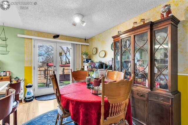 dining space featuring hardwood / wood-style floors, a textured ceiling, and french doors