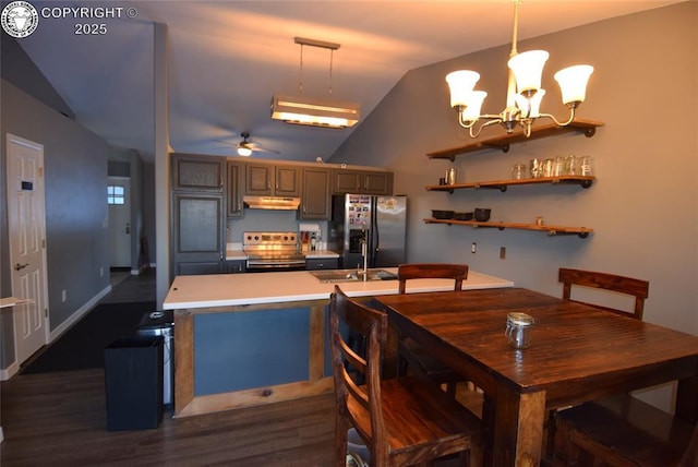 kitchen featuring ceiling fan with notable chandelier, appliances with stainless steel finishes, vaulted ceiling, and hanging light fixtures